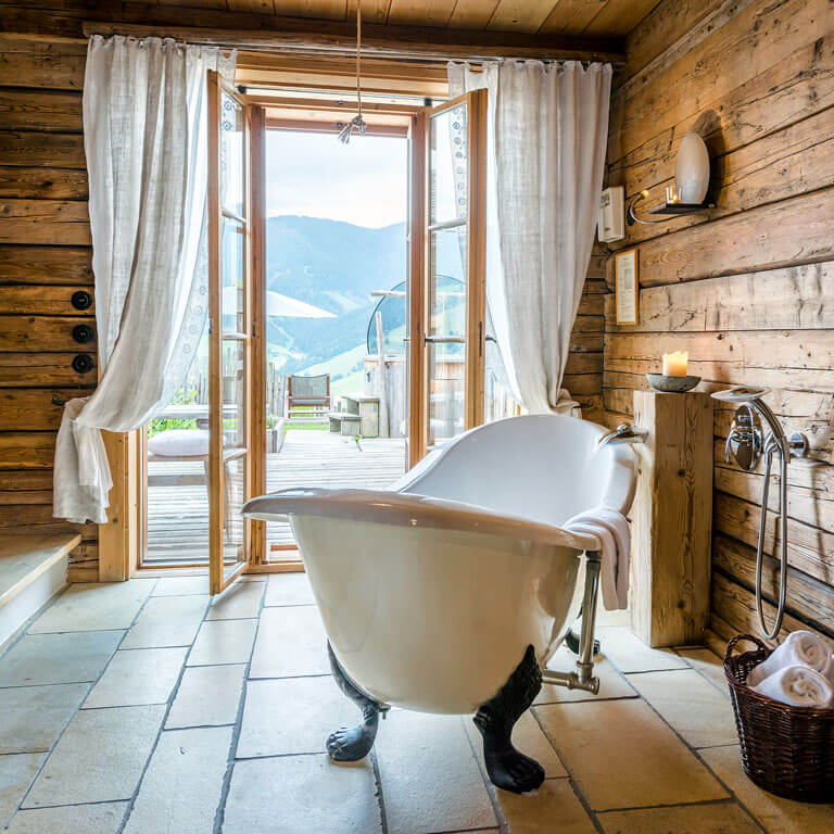 Entspannung pur in der Badewanne mit Bergblick | PRIESTEREGG Premium ECO Resort Almhuette mit Badewanne und Hot Pot in Oesterreich