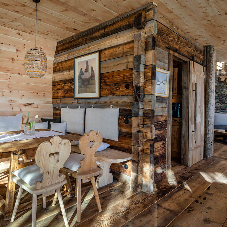 Viel Holz und Wärme auch am Esstisch in der Wilderer Villa Esszimmer mit Holz und Kissen in Luxus Chalet im Bergdorf