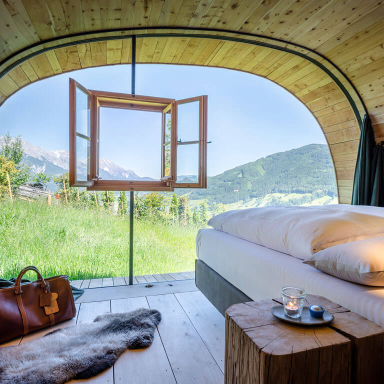 Schönstes Aufwachen mit diesem Blick | Schlafzimmer in der Wilderer Villa Bett mit Bergblick grüne Wiese Sommer Panoramafenster Luxus Chalet Priesteregg