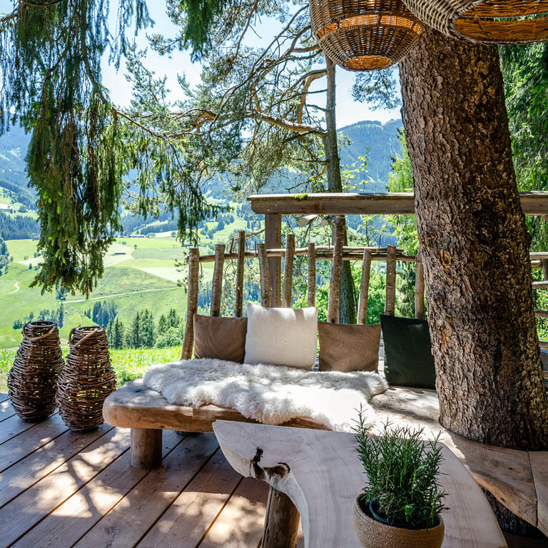 Gemütliche Ecke auf der Terrasse der Wilderer Villa | PRIESTEREGG Premium ECO Resort Sitzbank Gasrten Terrasse Wilderer Villa Chalet mit Bergblick Sommer Leogang