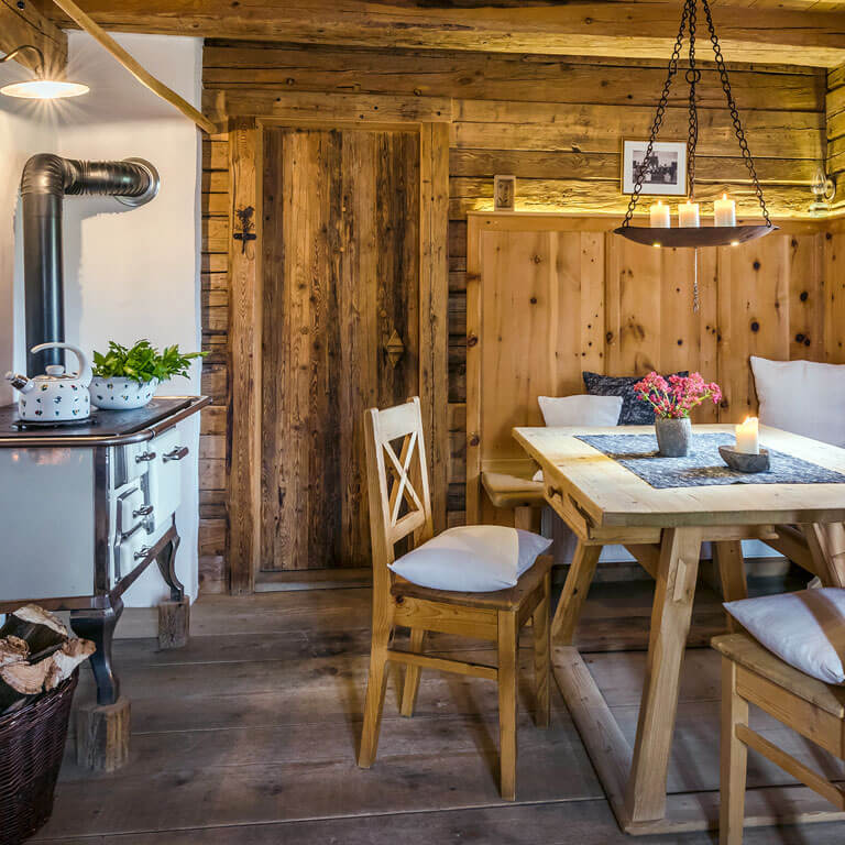 Gemütliche Bauernstube im Berg- und Premiumchalet | PRIESTEREGG Tisch und Ofen in Alm Holz Huette mit Komfort in Leogang