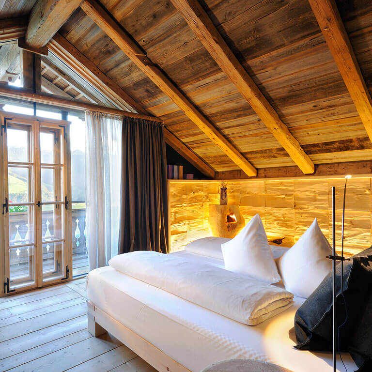 Gemütliches Schlafzimmer im Willy Bogner Chalet | PRIESTEREGG Schlafzimmer mit Balkon Luxus Chalet in Leogang Salzburger Land