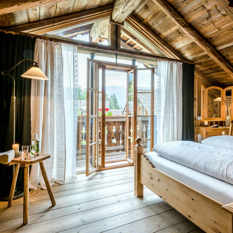 Zirbenschlafzimmer mit Balkon im Berg- und Premium Chalet | PRIESTEREGG Schlafzimmer aus Zirbenholz mit Balkon im Almdorf Priesteregg in Leogang