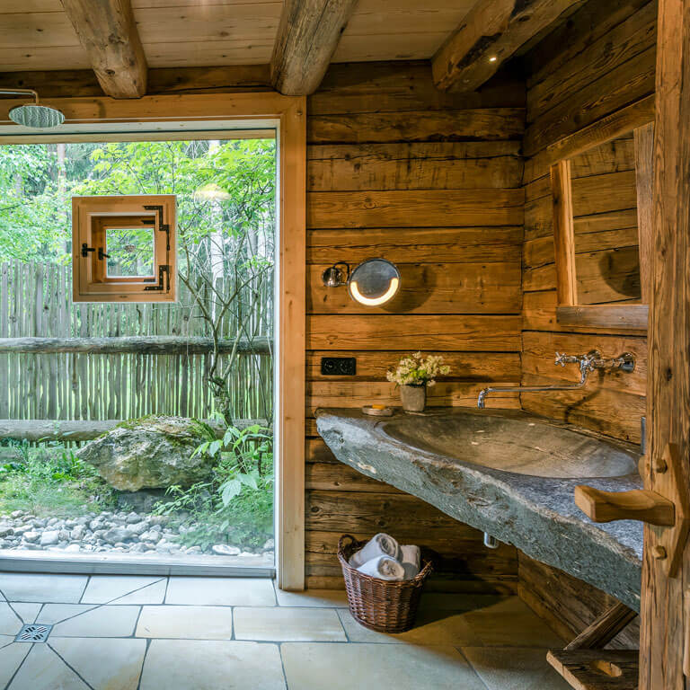 Ursprünglichkeit und Komfort im Premium Chalet | PRIESTEREGG Stein Waschbecken im natürlichen Badezimmer in der Huette im Priesteregg