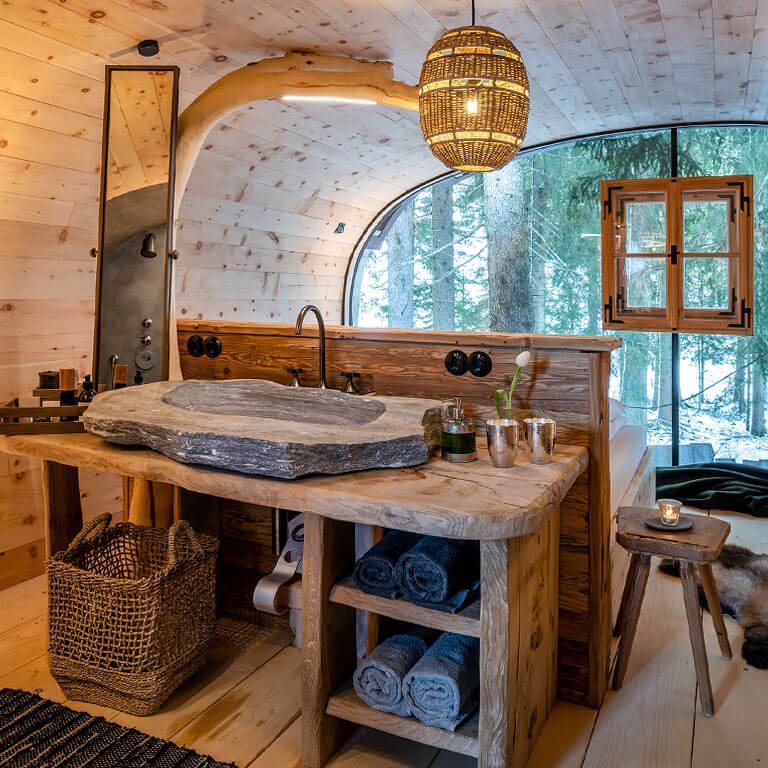 Badezimmer mit Waldblick | PRIESTEREGG Premium ECO Resort Steinwaschbecken Wilderer Villa Schlafzimmer Waldblick Berge Natur Leogang Österreich