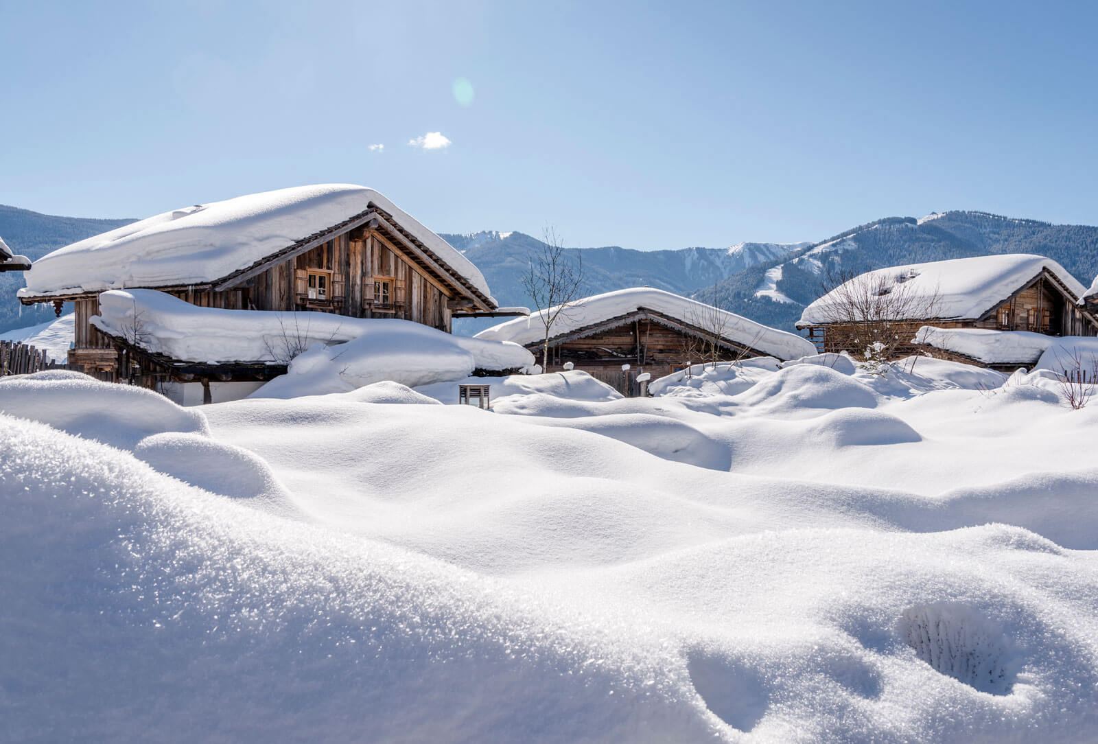 Luxus Chaletdorf im Schnee | PRIESTEREGG Premium ECO Resort Neuschnee im Huettendorf im Salzburger Land in Oesterreich